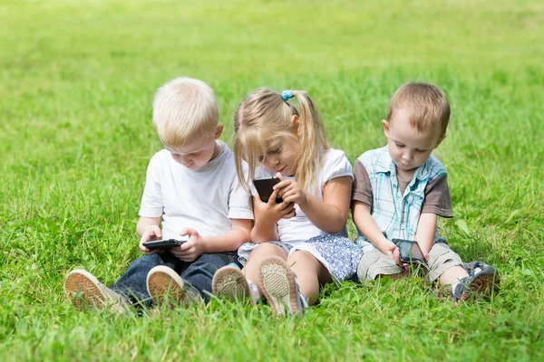 Bambini felici che giocano sugli smartphone — Foto Stock