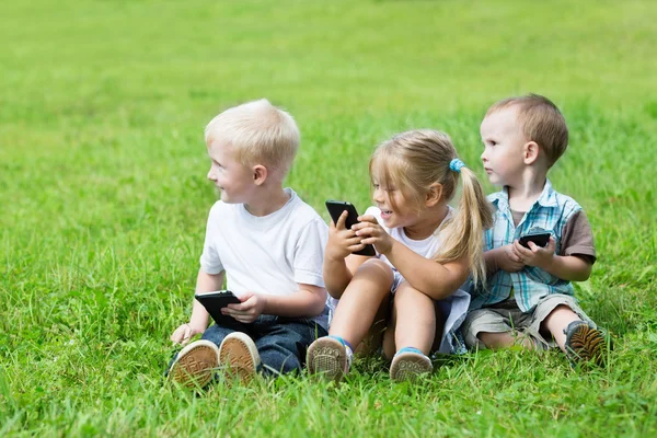 Brother and sister in garden sitting on the grass — Stock Photo, Image