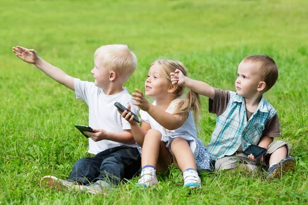 Fröhliche kleine Kinder spielen im Park — Stockfoto
