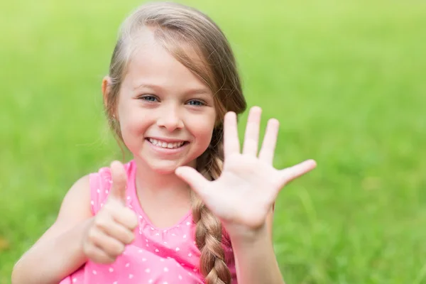 Усміхнена дівчина показує великий палець вгору — стокове фото