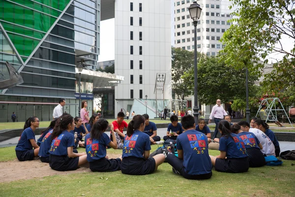 Meninos e meninas sentados no centro de Singapura — Fotografia de Stock