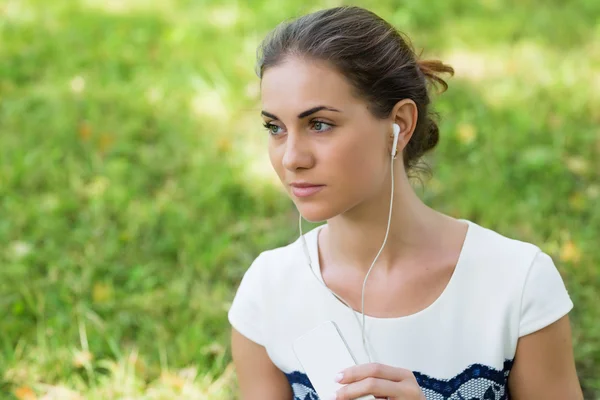 Meisje muziek afkomstig van slimme telefoon beluisteren — Stockfoto