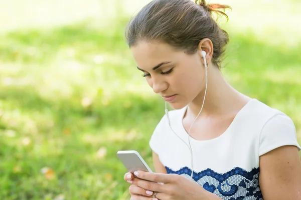 Meisje kijken naar video's in een slimme telefoon — Stockfoto