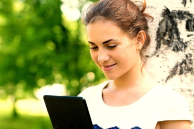 Dijital tablet ile gülümseyen genç kadın