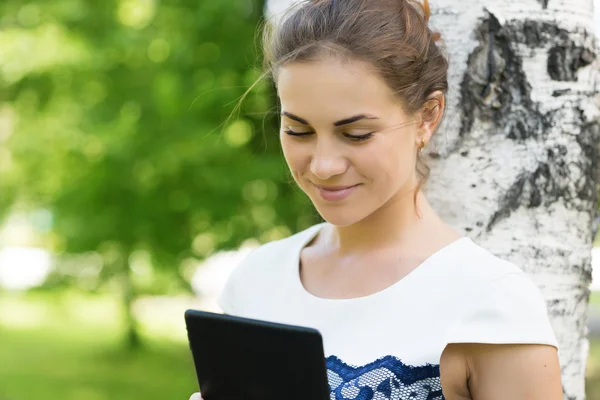 デジタル タブレットを持つ若い女性を笑顔 — ストック写真