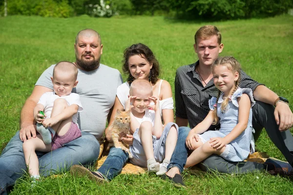 Large family with a cat on the lawn — Stock Photo, Image