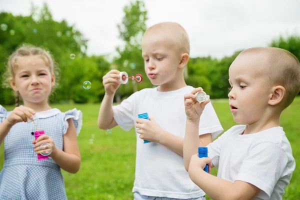 Kleine broers en zus zeepbellen blazen — Stockfoto