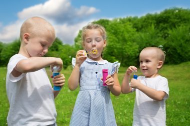 Mutlu kız ve erkek kardeşim sabun köpüğü şişirmek