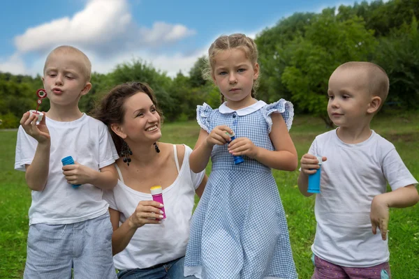 Mutter und Kind pusten Seifenblasen — Stockfoto