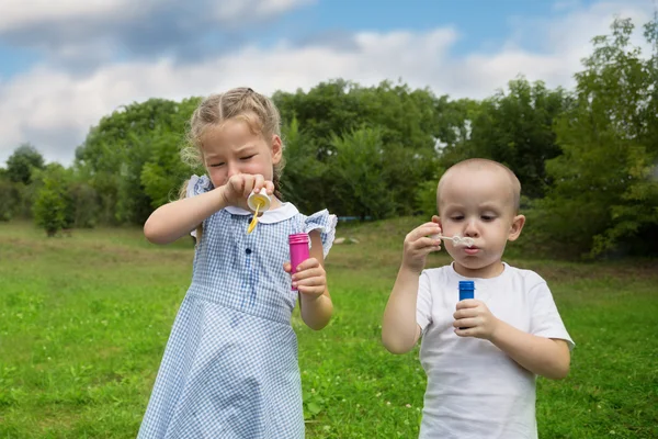 Bror och syster blåser såpbubblor — Stockfoto