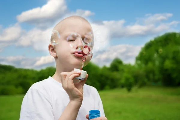 Ragazzo gonfia bolle di sapone — Foto Stock