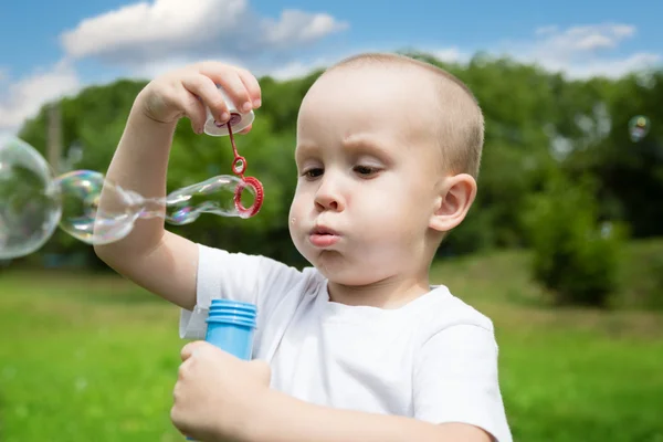 Malý chlapec fouká mýdlové bubliny — Stock fotografie