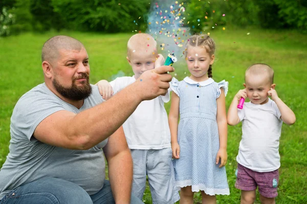 Father shoots of the firecracker with confetti — Stock Photo, Image