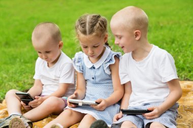 Mutlu kardeşler ve kız kardeşi akıllı telefonlar kullanarak