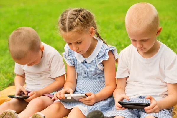 Brothers and sister using smart phones — Stock Photo, Image