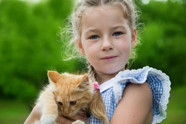 Preciosa chica con un gatito en sus brazos — Foto de Stock