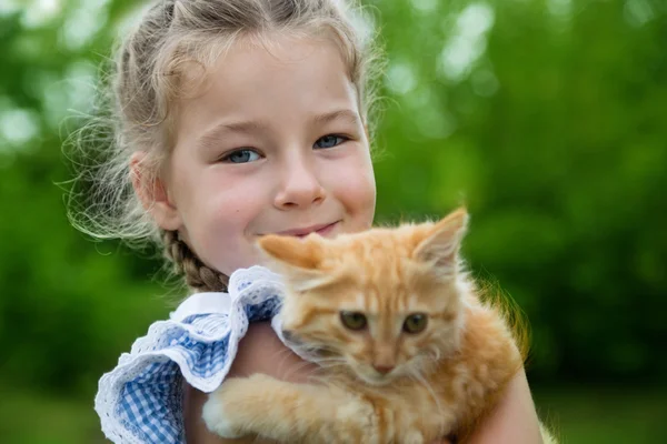 Chica jugando con un gatito rojo — Foto de Stock