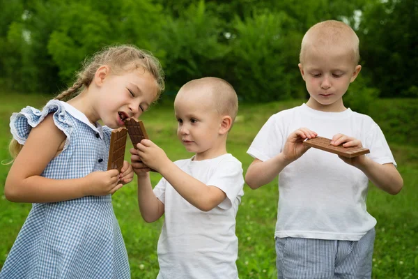 Küçük rothers ve yeme çikolata kız kardeşi — Stok fotoğraf
