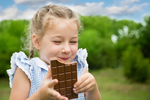 Радостная девушка ест шоколад — стоковое фото
