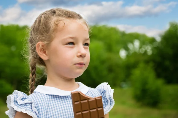 Petite fille avec plaisir est chocolat . — Photo