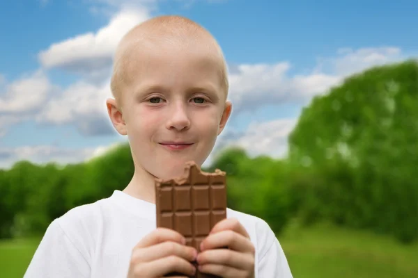 Zevk ile neşeli küçük çocuk çikolata yiyor — Stok fotoğraf