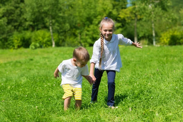 Glad bror och syster leker i parken — Stockfoto