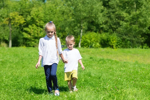 Frère et sœur marchent dans un parc d'été — Photo