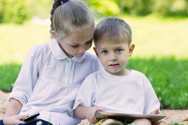 Crianças usando um tablet PC e smartphone — Fotografia de Stock