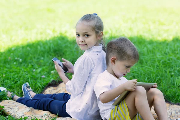 Söta barn som använder tablet Pc och smartphone — Stockfoto