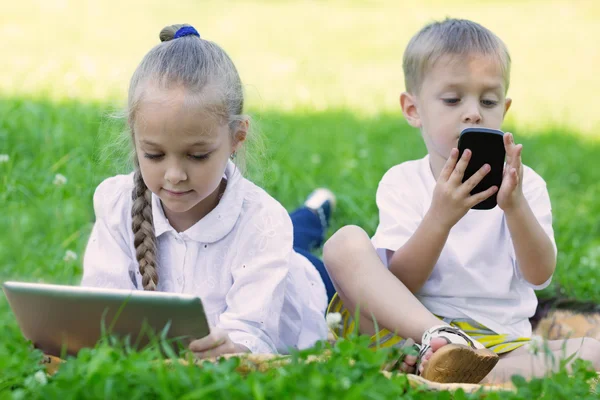 Enfants utilisant une tablette PC et un smartphone — Photo