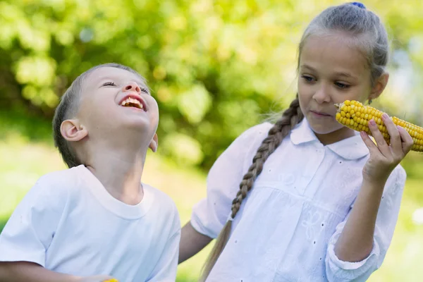 Bambini gioiosi che mangiano mais all'aperto — Foto Stock