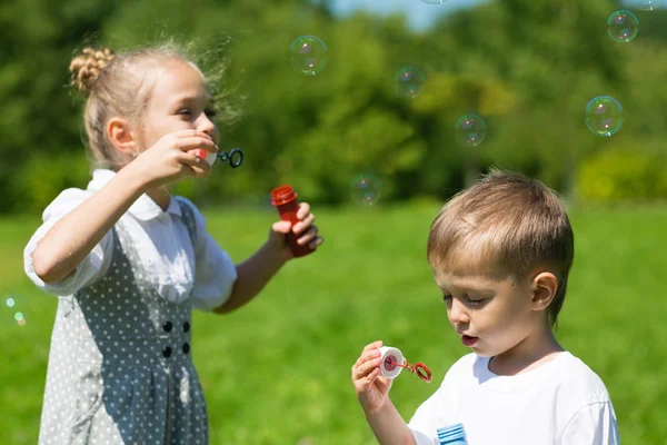 Beaux enfants soufflent des bulles dans le parc — Photo