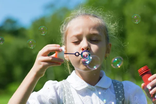 Roztomilé dívka foukání mýdlo bubliny — Stock fotografie