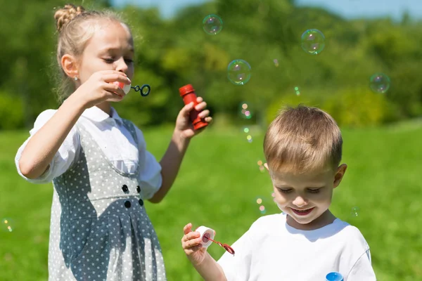 Милые дети пускают мыльные пузыри — стоковое фото