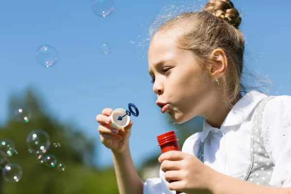 Söt liten flicka blåser såpbubblor — Stockfoto