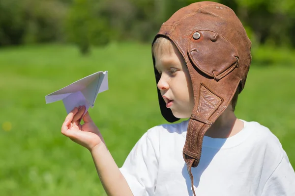 Menino no velho piloto de capacete brincando com avião de brinquedo — Fotografia de Stock