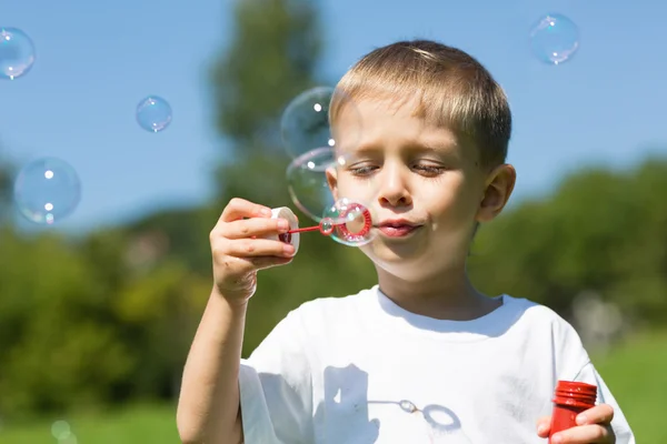 Cute boy blowing soap bubbles Royalty Free Stock Photos