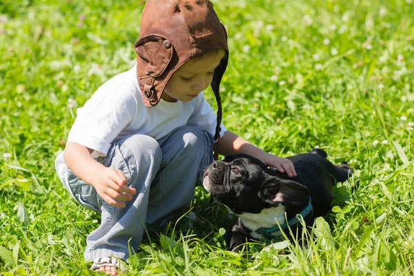 Menino brincando com o cão Bulldog francês — Fotografia de Stock