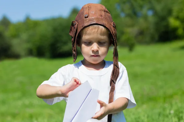 Pequeno menino bonito jogando avião de papel — Fotografia de Stock