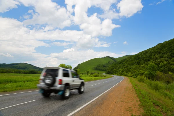 Automóvil en movimiento en la carretera al atardecer — Foto de Stock