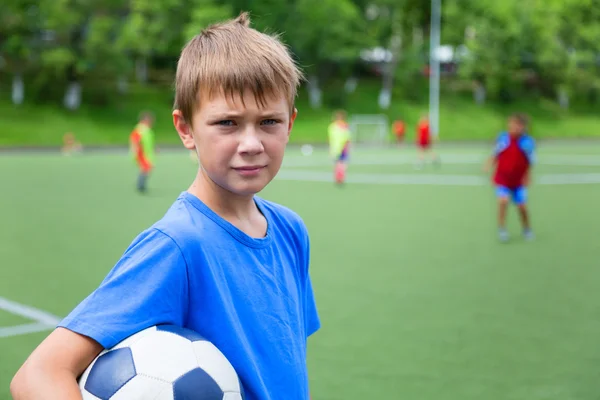 Pojke fotbollsspelare med en boll i ett stadium — Stockfoto