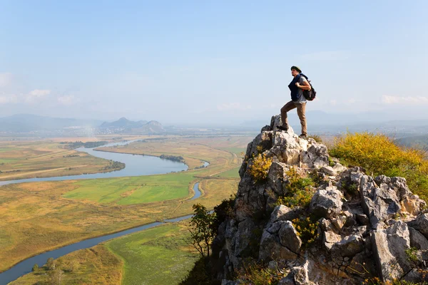 Hiker man climbed a mountain and admire nature — Stock fotografie