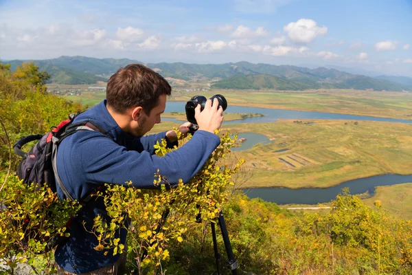 Photographer on the camera shoots neighborhood — Stock Photo, Image