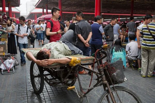 Man resting on a rickshaw of Panjiayuan Antique Market, Beijing — Zdjęcie stockowe