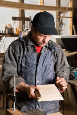 Marangoz ahşap bir mobilya parçası tutar