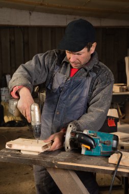 Marangoz matkapla çalışıyor.