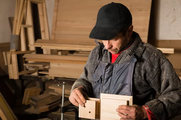 Carpintero trabaja con madera en el taller — Foto de Stock