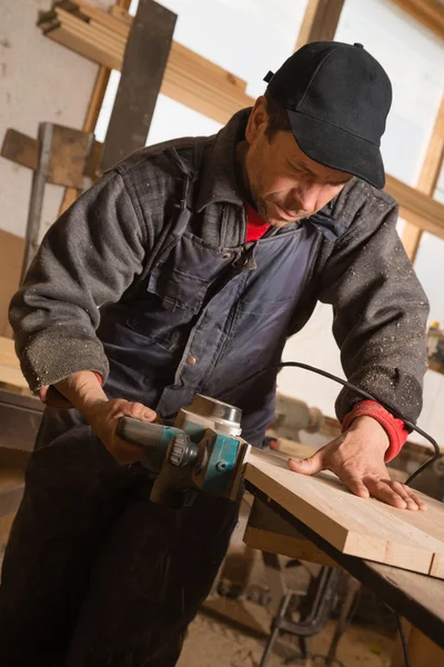 Carpenter working electric planer — Stock Photo, Image