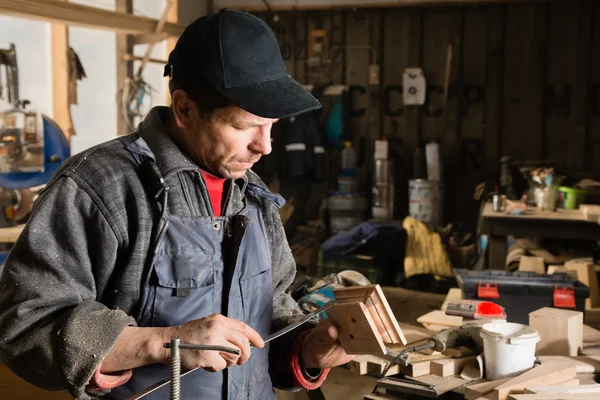 Joiner is engaged in manufacturing wooden part — Stock Photo, Image