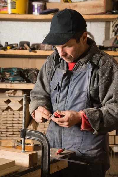 Carpintero trabaja con madera en el taller — Foto de Stock